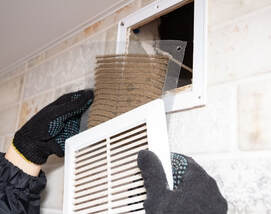 man with gloves taking out the filter from dryer vent